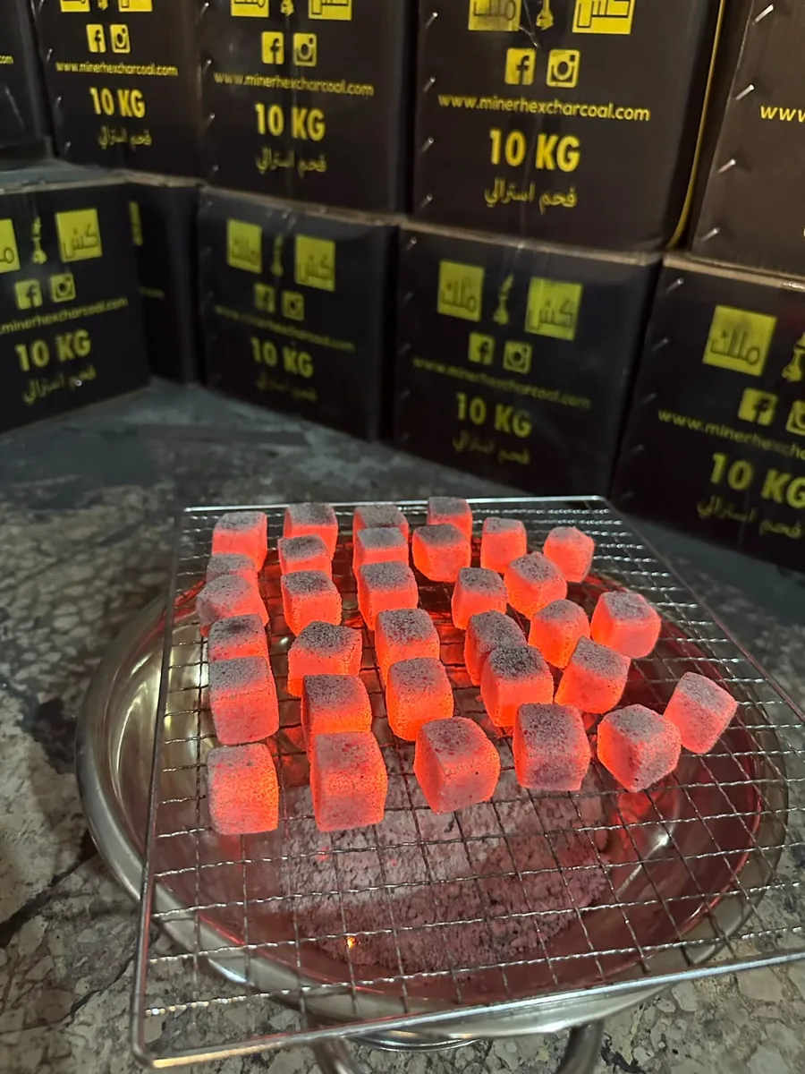 Minerhex cube charcoal glowing red on a burner, with stacked 10 kg boxes behind